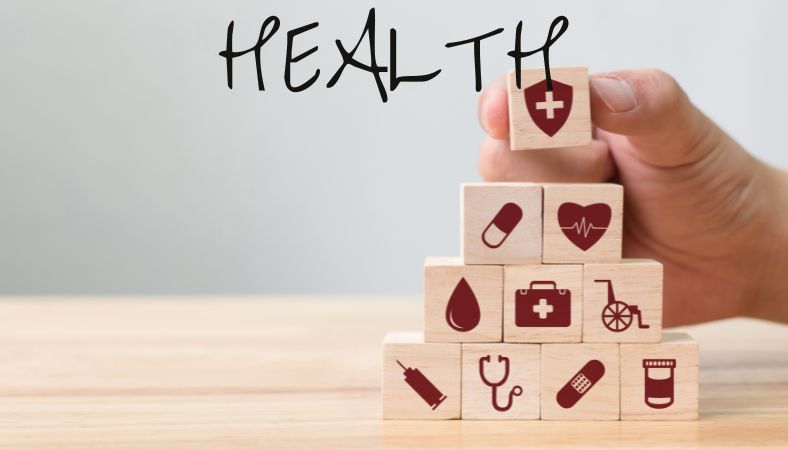 Wooden building blocks with health related images on each one like a medical bag and pill